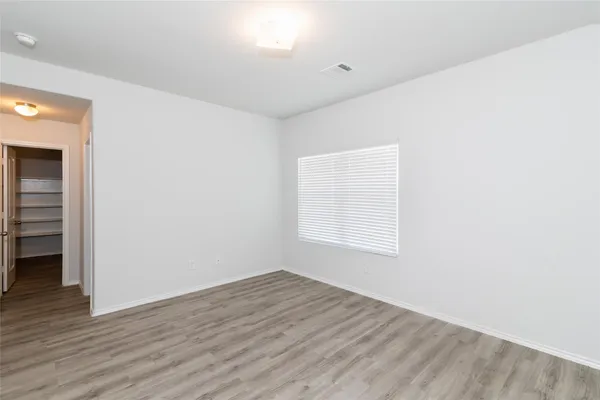 an empty room with wooden floor and window