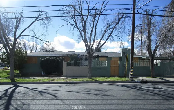 a view of a house with a yard and large tree