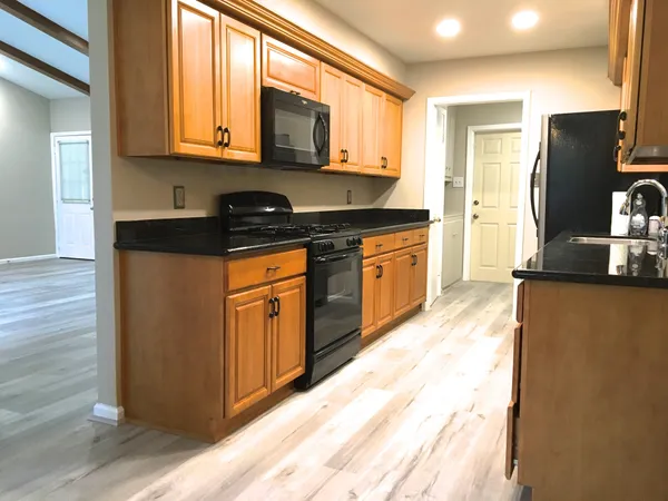 a kitchen with stainless steel appliances granite countertop a refrigerator a stove a sink and a microwave