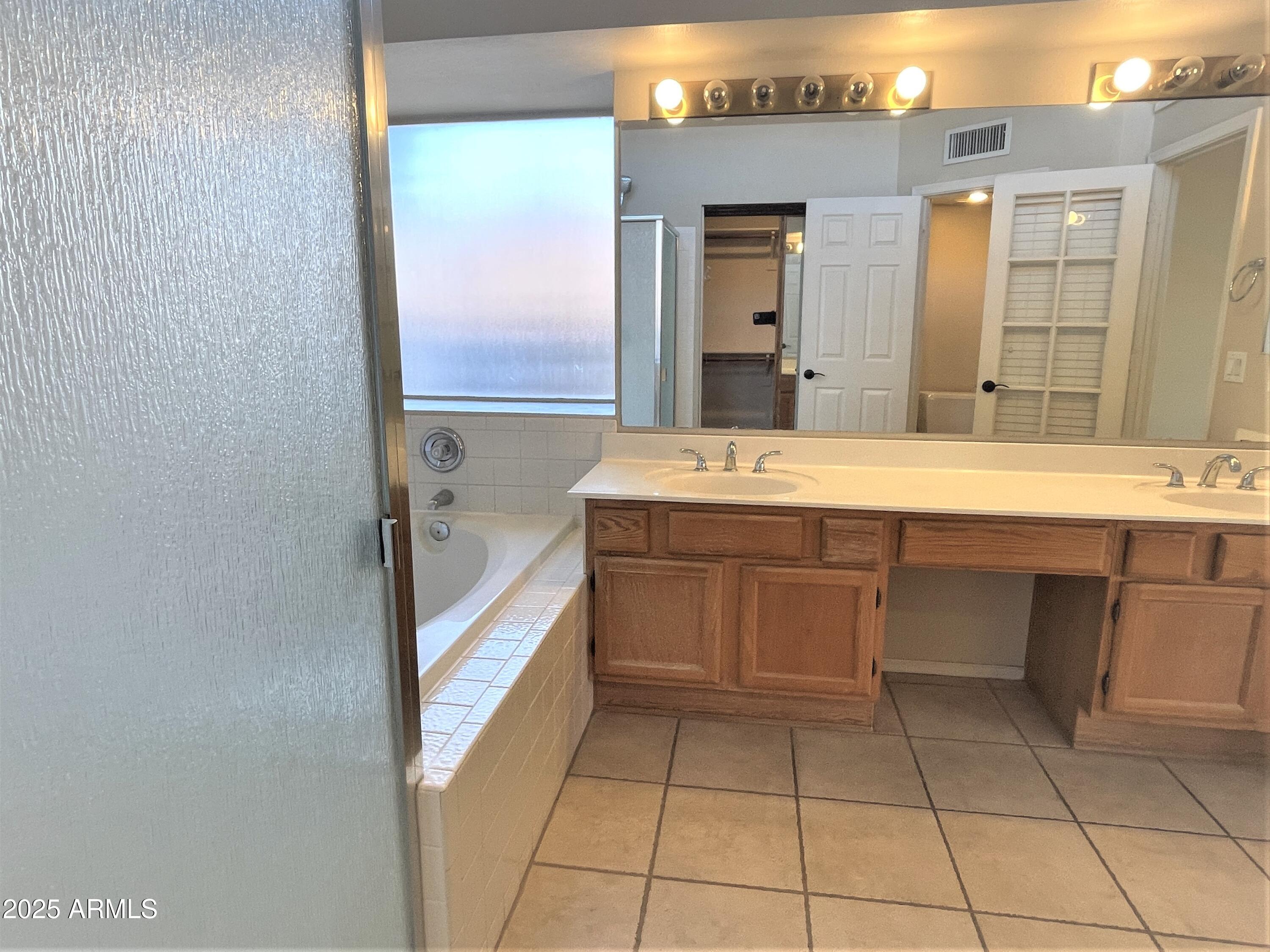1310 North Longmore Street Chandler, AZ 85224 - Photo 19 of 32 a bathroom with a sink a mirror and a bathtub