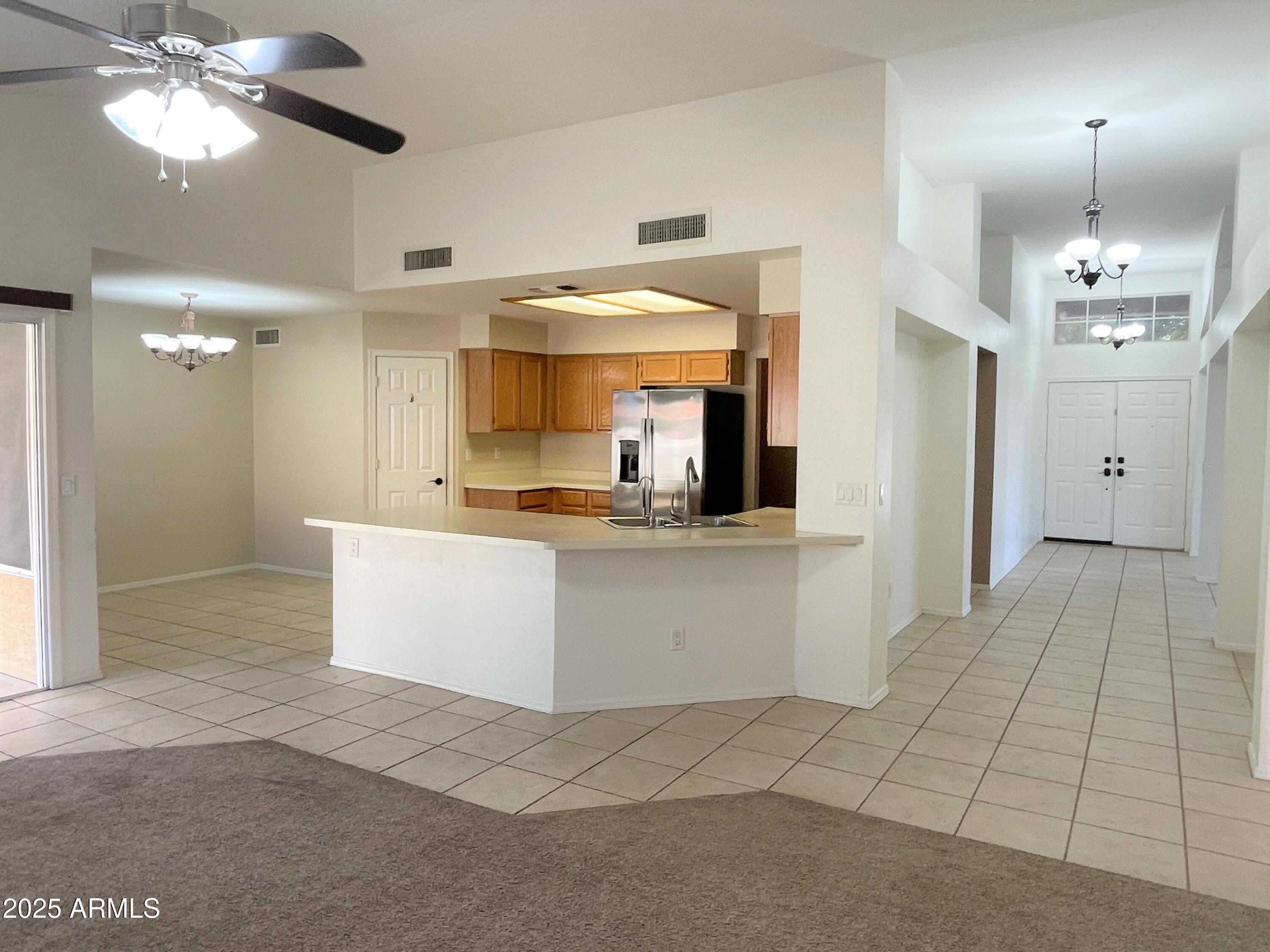 1310 North Longmore Street Chandler, AZ 85224 - Photo 9 of 32 a large white kitchen with kitchen island a chandelier stainless steel appliances cabinets and a counter top space