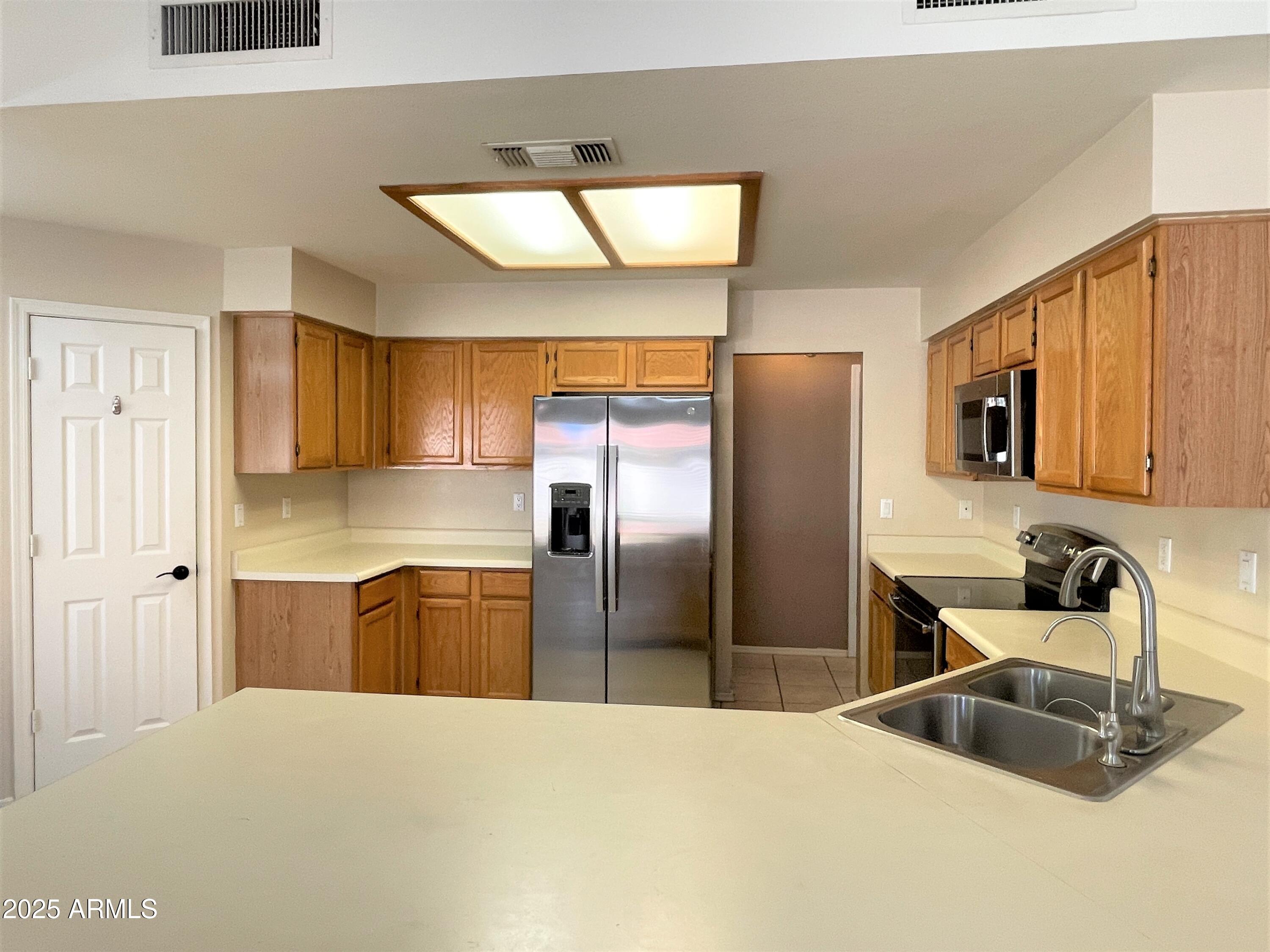 1310 North Longmore Street Chandler, AZ 85224 - Photo 10 of 32 a kitchen with stainless steel appliances granite countertop a refrigerator a sink and a stove