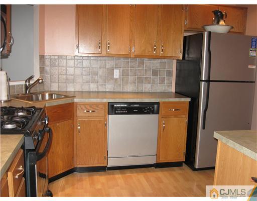 36 Farnham Square Sayreville, NJ 08859 - Photo 3 of 16 a kitchen with a sink a refrigerator and a stove