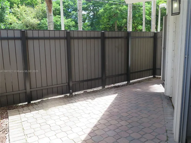 a view of a patio with table and chairs with wooden floor and fence