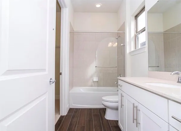 a kitchen with kitchen island stainless steel appliances a stove a sink cabinets and wooden floor