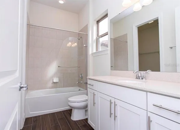 a kitchen with kitchen island granite countertop a sink cabinets and wooden floor
