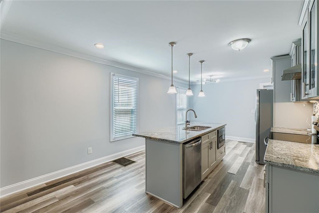 677 Ira Street Southwest Atlanta, GA 30310 - Photo 9 of 28 a kitchen with stainless steel appliances granite countertop a sink and a stove