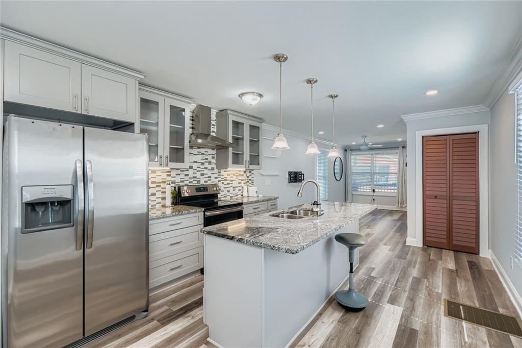 677 Ira Street Southwest Atlanta, GA 30310 - Photo 10 of 28 a kitchen with stainless steel appliances kitchen island granite countertop a refrigerator and a stove