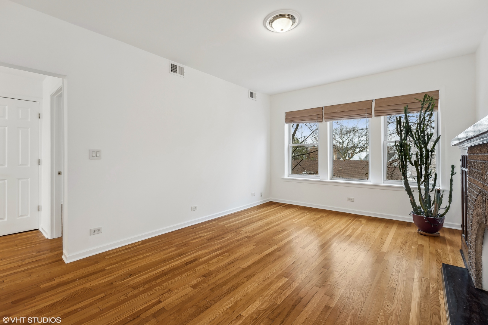3317 West George Street, Unit 2 Chicago, IL 60618 - Photo 5 of 15 an empty room with wooden floor and windows