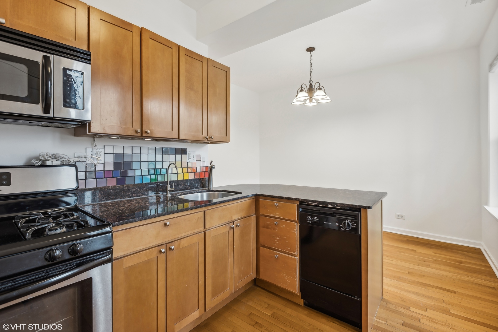 3317 West George Street, Unit 2 Chicago, IL 60618 - Photo 6 of 15 a kitchen with stainless steel appliances granite countertop a stove a sink and a microwave