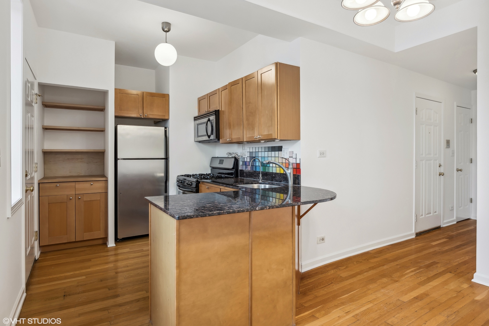 3317 West George Street, Unit 2 Chicago, IL 60618 - Photo 7 of 15 a kitchen with stainless steel appliances granite countertop a refrigerator a stove and a wooden floors