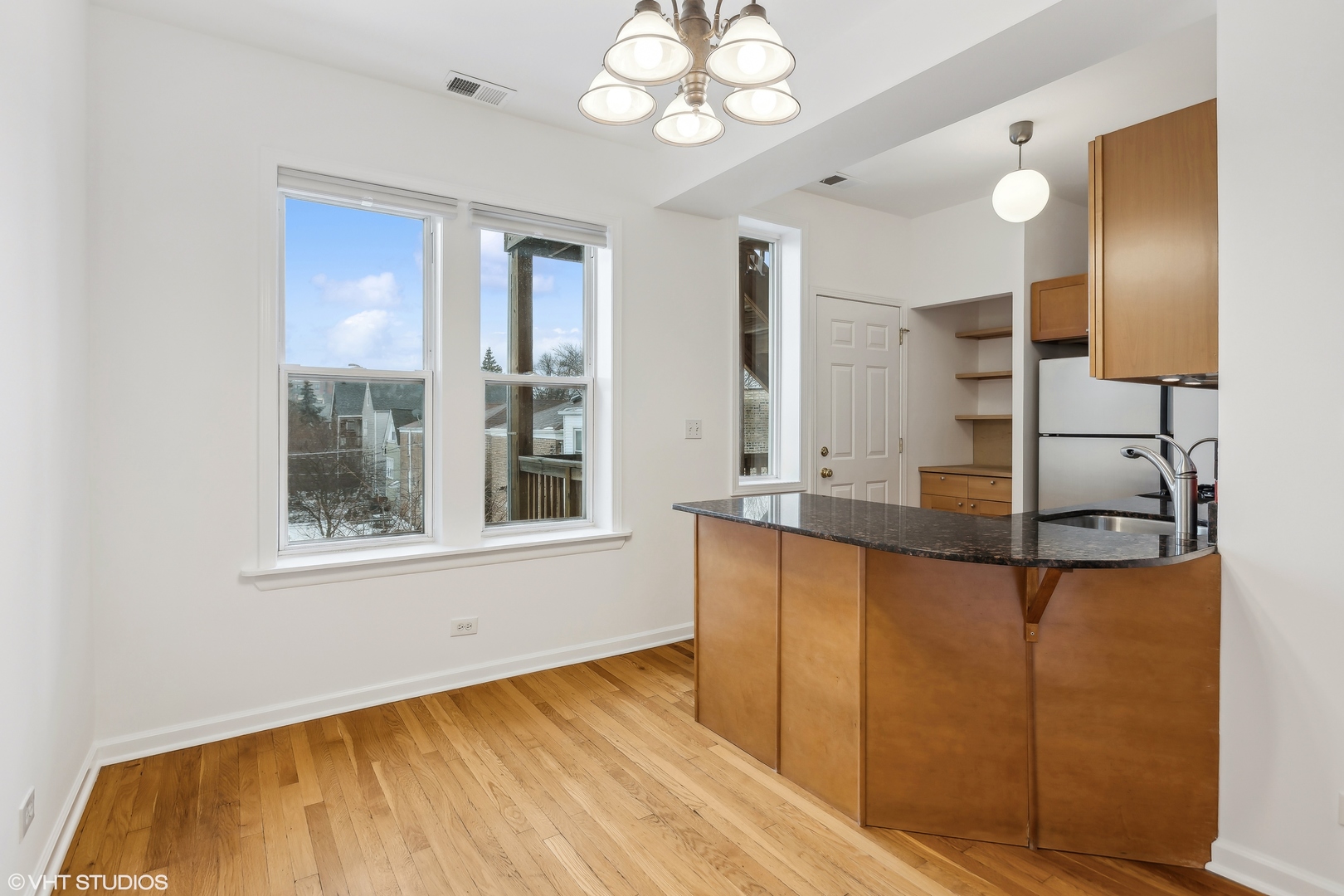 3317 West George Street, Unit 2 Chicago, IL 60618 - Photo 8 of 15 a view of a kitchen with kitchen island a sink wooden floor and a large window
