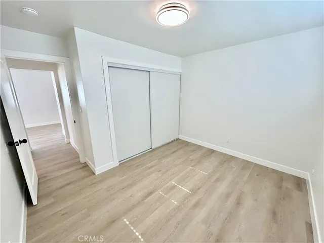 an empty room with wooden floor and staircase