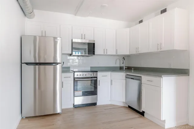 a kitchen with stainless steel appliances granite countertop a refrigerator sink and stove