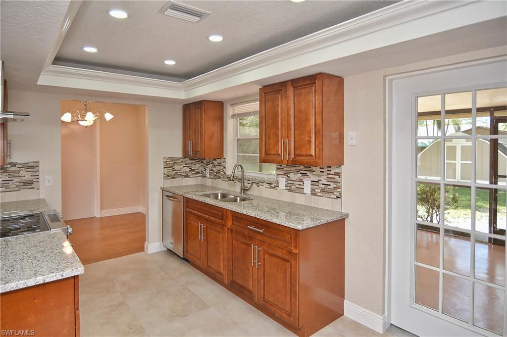 19070 Evergreen Road Fort Myers, FL 33967 - Photo 14 of 25 a bathroom with a granite countertop sink a mirror and a shower