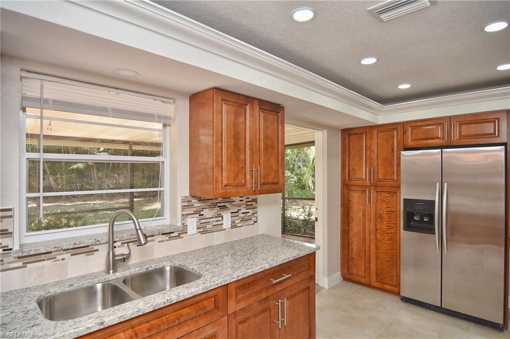 19070 Evergreen Road Fort Myers, FL 33967 - Photo 18 of 25 a kitchen with stainless steel appliances granite countertop a sink and a refrigerator
