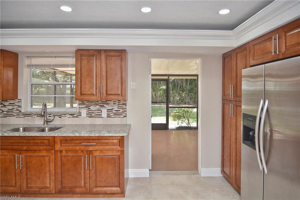 19070 Evergreen Road Fort Myers, FL 33967 - Photo 19 of 25 a bathroom with a granite countertop sink a mirror and a shower