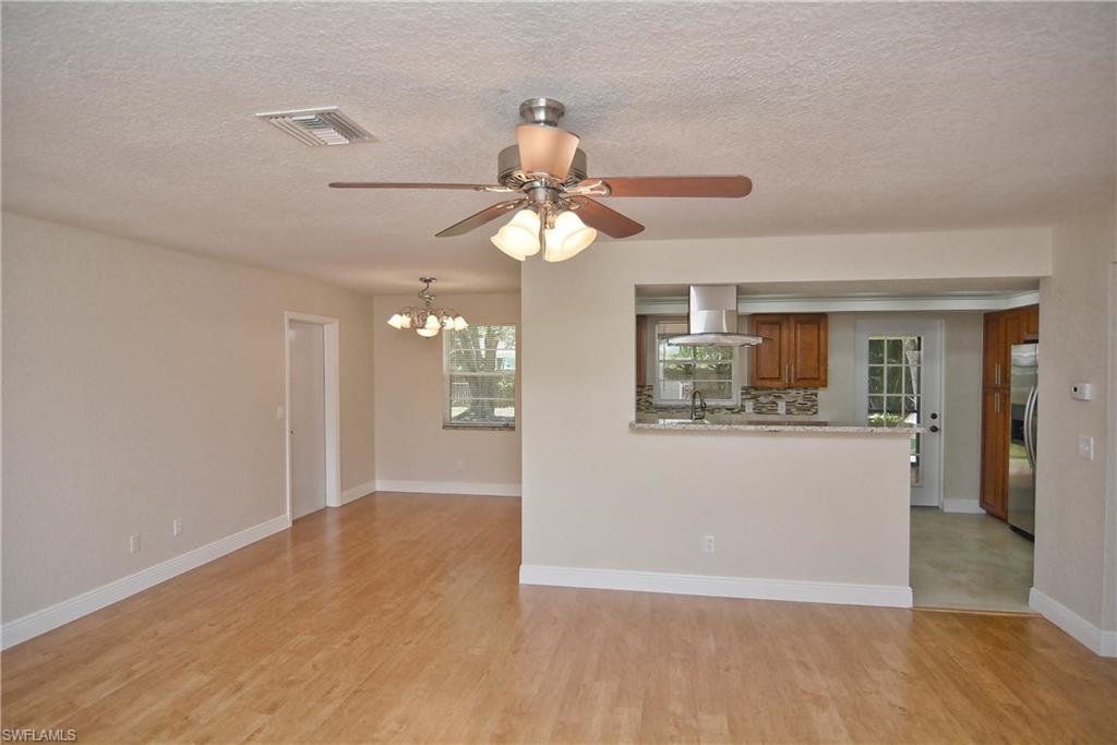 19070 Evergreen Road Fort Myers, FL 33967 - Photo 4 of 25 a view of a room with wooden floor and chandelier