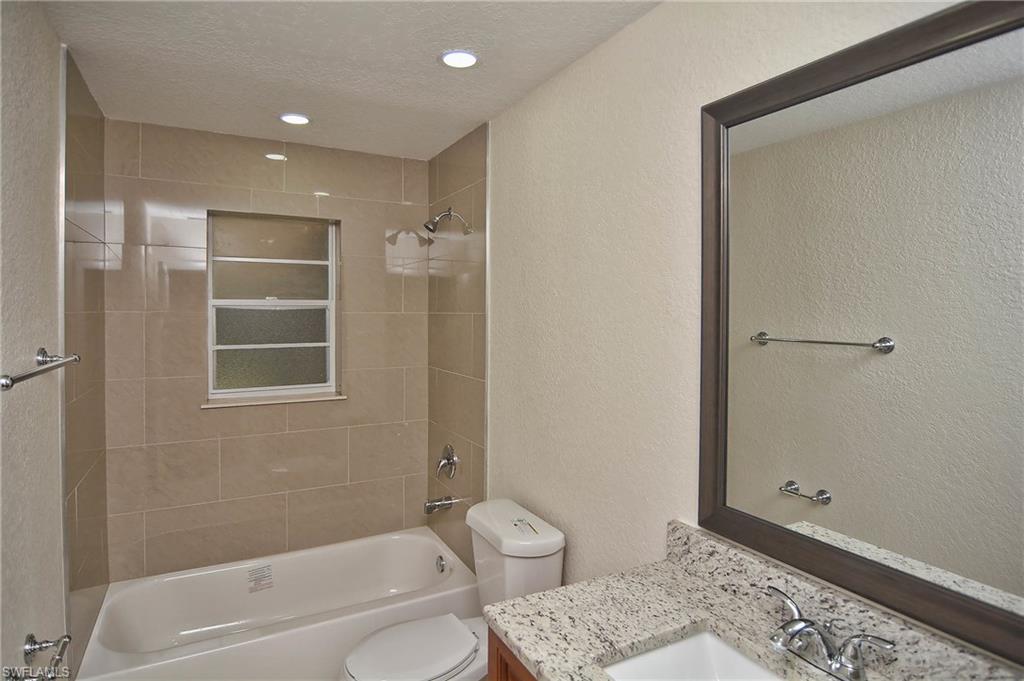 19070 Evergreen Road Fort Myers, FL 33967 - Photo 5 of 25 a bathroom with a granite countertop sink a toilet and shower
