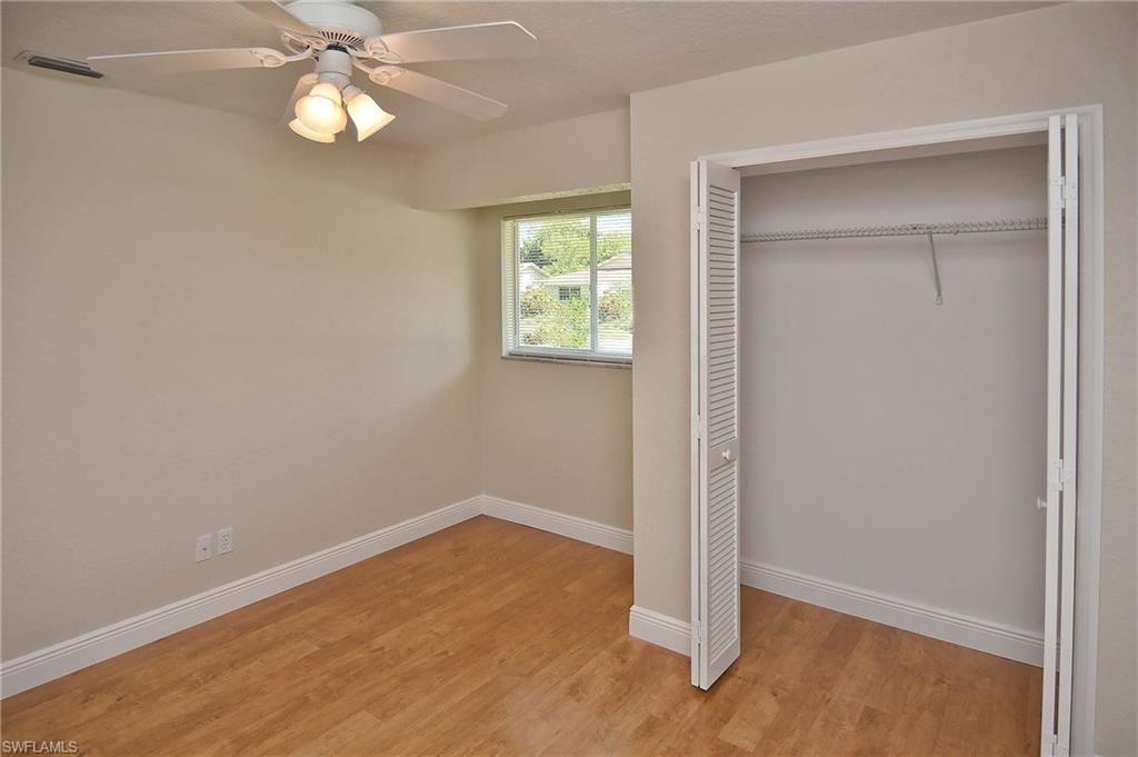 19070 Evergreen Road Fort Myers, FL 33967 - Photo 7 of 25 an empty room with wooden floor closet and windows