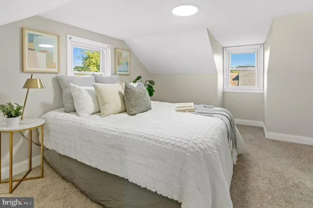 a bedroom with a bed and painting on the wall