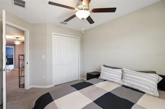 a bedroom with a bed and a ceiling fan