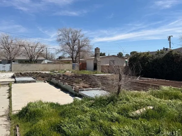 a view of a yard with wooden fence