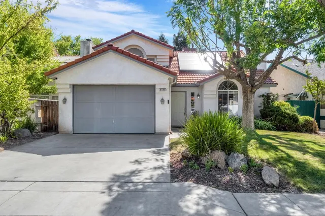 a front view of house with yard and trees around