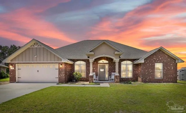 a front view of a house with yard and green space