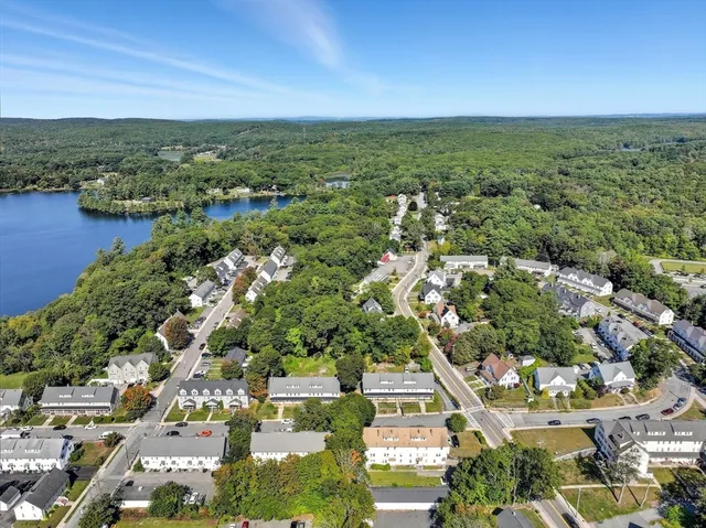 an aerial view of residential houses with outdoor space and trees