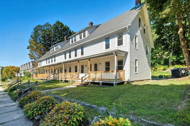 a front view of a house with a yard table and a large tree