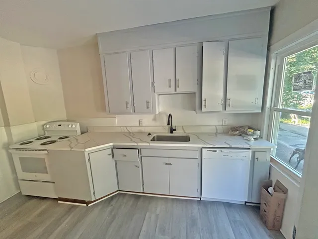 a kitchen with a sink cabinets and wooden floor