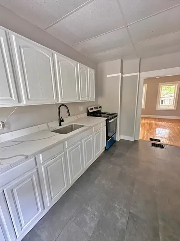 a kitchen with white cabinets and white appliances