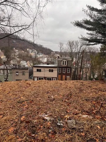 a view of a dry yard with wooden fence