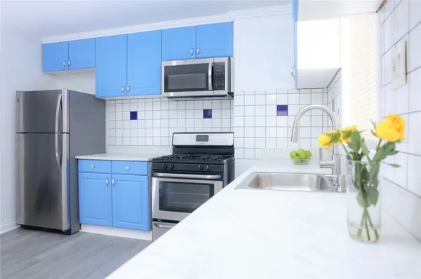a kitchen with stainless steel appliances a stove microwave and refrigerator