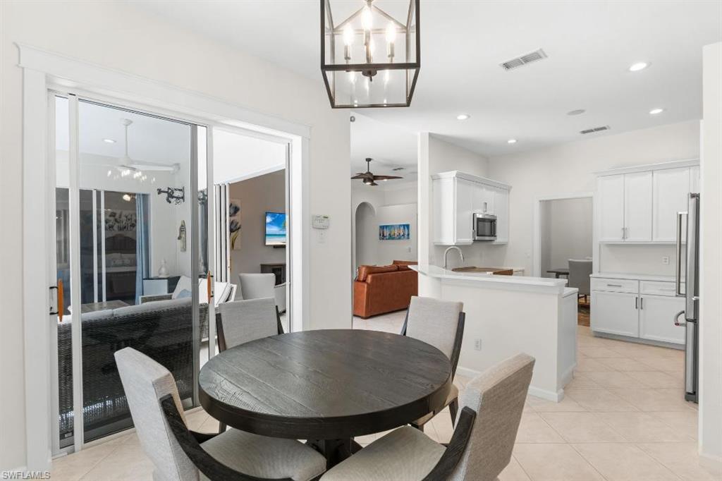 20117 Seadale Court Estero, FL 33928 - Photo 11 of 34 Recessed lighting, tile flooring, white shaker cabinetry, stainless steel appliances, and a glass-paneled sliding door