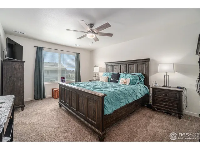 a bed room with a bed and a ceiling fan