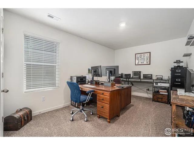 a view of a workspace with furniture and a window