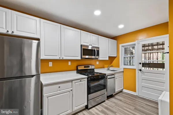 a kitchen with stainless steel appliances a stove microwave and refrigerator