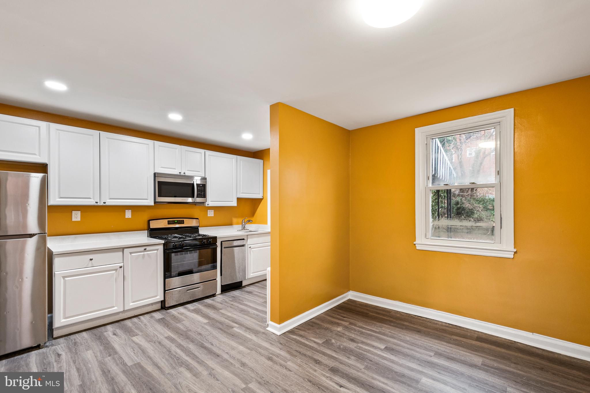2412 18th Street Southeast Washington, DC 20020 - Photo 15 of 33 a kitchen with stainless steel appliances white cabinets and wooden floor