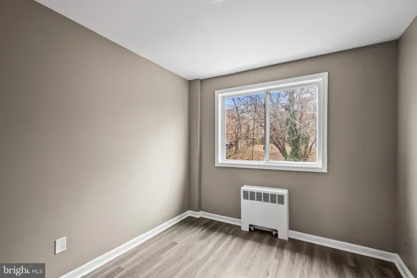 a view of room with window and wooden floor
