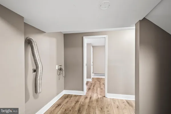 a view of a room with wooden floor and a bathroom