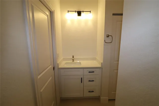 a bathroom with a granite countertop sink and mirror with shower