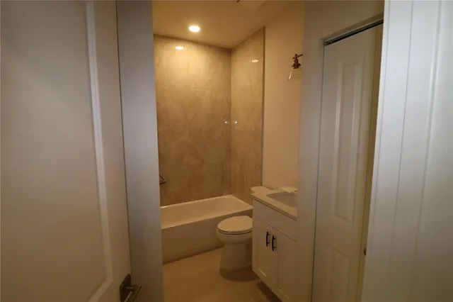 a bathroom with a granite countertop toilet a sink and a bathtub