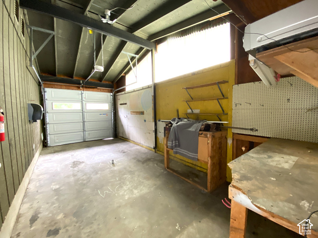 2989 Rae Street West Valley City, UT 84120 - Photo 25 of 25 Concrete floor, overhead garage door, built-in shelving, wall-mounted pegboard, wall-mounted air conditioning unit