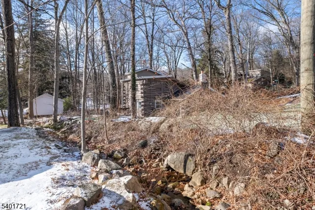 a view of a house with a yard covered by trees