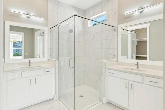 a bathroom with a double vanity sink mirror and shower