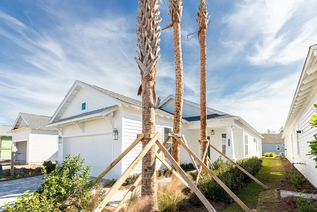 a view of a house with a small yard and potted plants