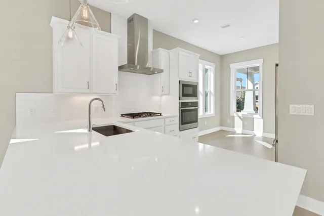a kitchen with granite countertop a sink stainless steel appliances and cabinets