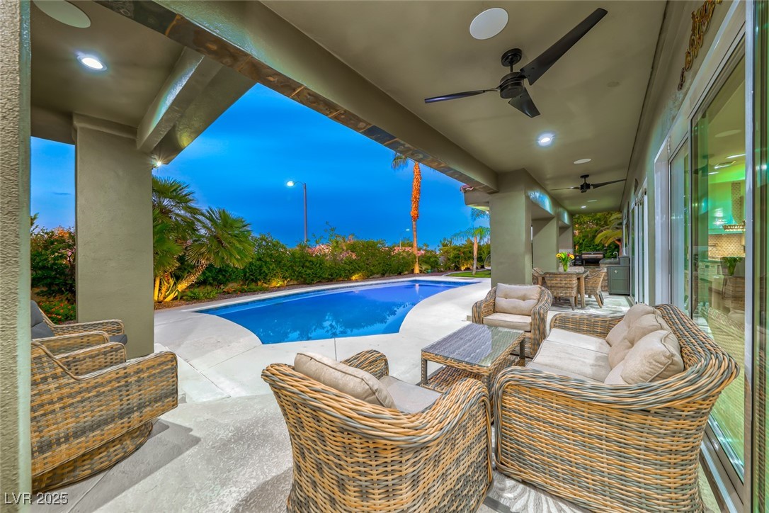 Swimming pool with ceiling fan, a patio area, and an outdoor living space